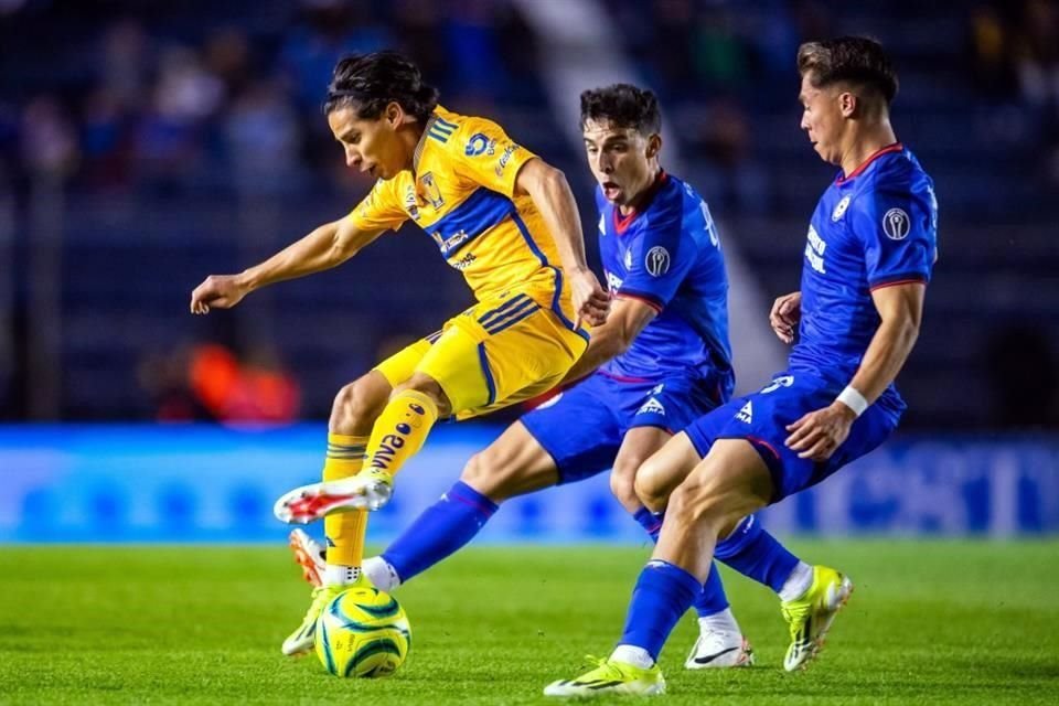 Diego Lainez trata de salir entre dos rivales.