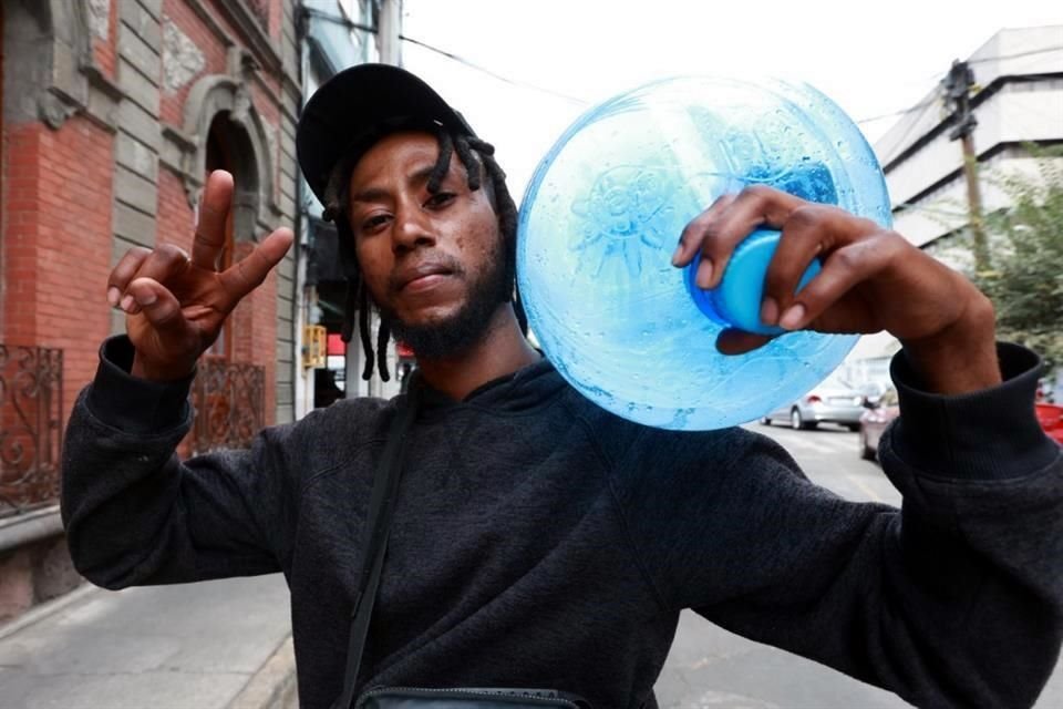 Peterson Abbrir, un joven haitiano que busca llegar a EU, reparte garrafones de agua en la Colonia Guerrero.