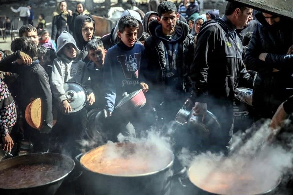 Los palestinos se reúnen para recolectar alimentos de ayuda en Beit Lahia, en medio de continuas batallas entre Israel y el grupo militante palestino Hamas.