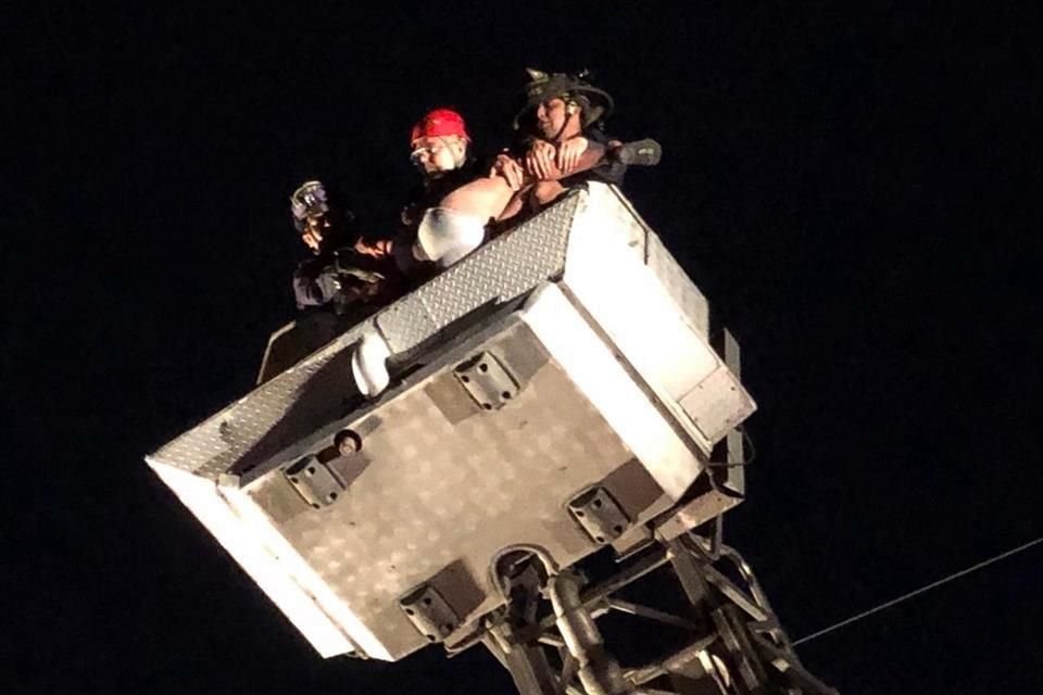 Cuerpos de Bomberos y Protección Civil estatal bajan al sujeto de la torre por la fuerza.