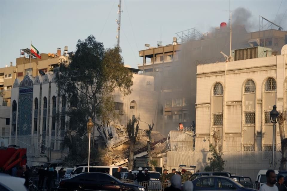 Servicios de emergencia trabajan en un edificio destruido tras un ataque aéreo en Damasco, Siria.