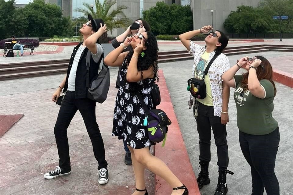 Jóvenes apreciando el inicio del eclipse desde la Macroplaza.