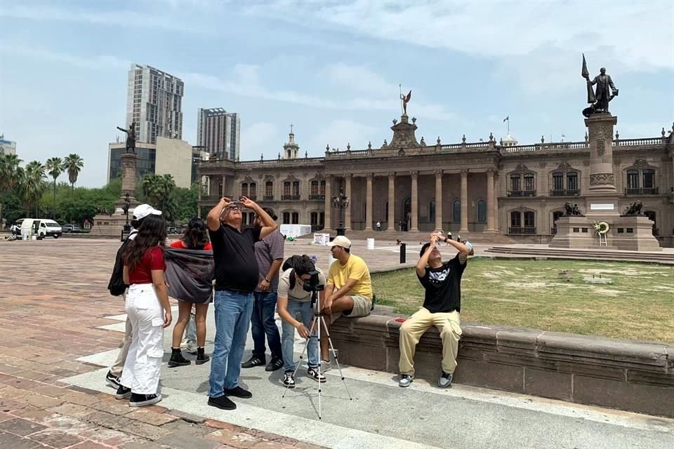 Estudiantes de Comunicación de la Metropolitana instalaron una cámara fotográfica con un filtro e invitaban a loS paseantes a mirar el espectáculo solar histórico.