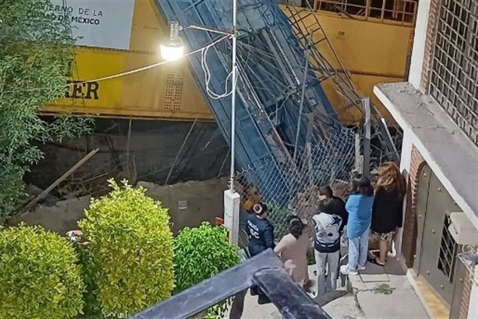 Vecinos observan durante la madrugada la lanzadora de dovelas que cayó a un lado de una de las casas.