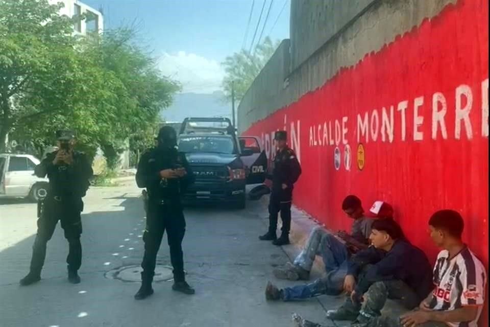 Policías de Fuerza Civil retuvieron a unos jóvenes que pintaban una barda con publicidad de Adrián de la Garza.