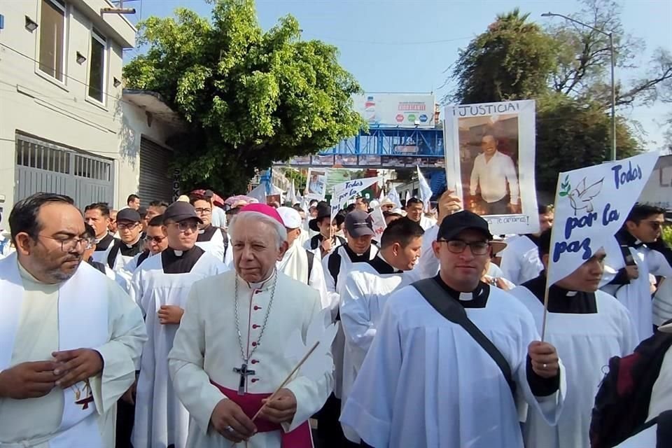 En el contingente se alzan pancartas con demandas de paz y de justicia, y fotos de personas desaparecidas o víctimas de violencia, y se escuchan himnos católicos.