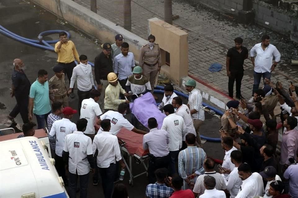 Los rescatistas transportan cadáveres de personas que murieron en un incendio que se desató en un parque de diversiones.