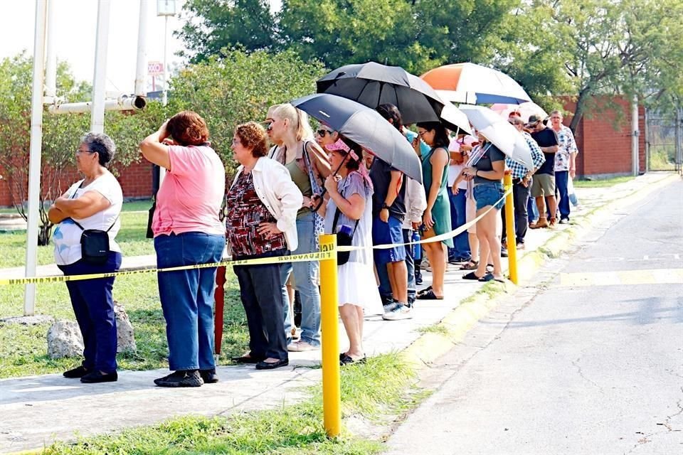 Muchos votantes sacaron las sombrillas para protegerse del sol.