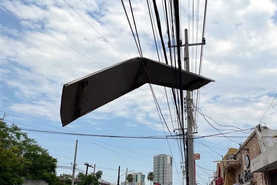 Aparentemente, la lámina salió volando de un anuncio panorámico que se ubica cerca del lugar donde ahora se mantiene enredada con los cables.
