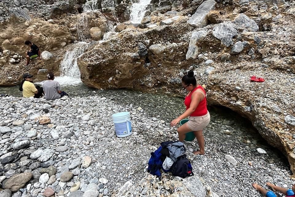 Vecinas lavan ropa y trapeadores para limpiar sus casas, en Santa Catarina.