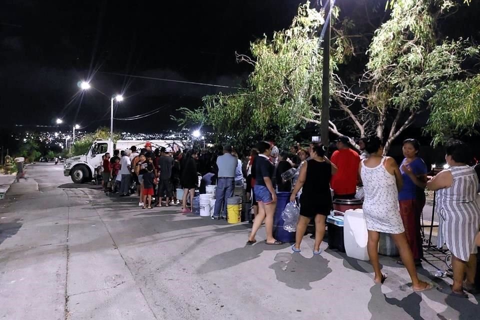 Los vecinos formaron una larga fila para obtener algo de agua de las pipas.