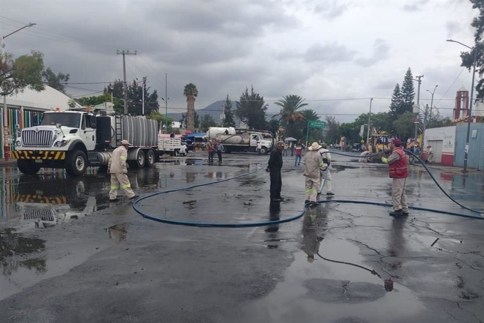 Vehículos con sistemas de succión intentan limpiar la red de drenaje saturada de agua en las vialidades.