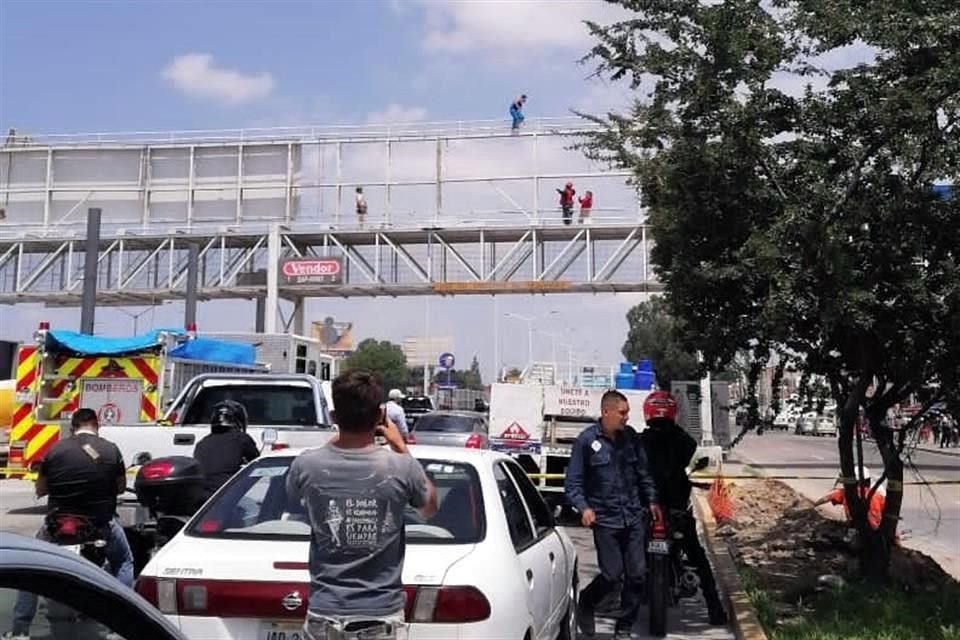 Por más de una hora, bomberos de Zapopan han intentado convencer a un hombre para que se baje del puente peatonal en Periférico y la Avenida Federalismo.