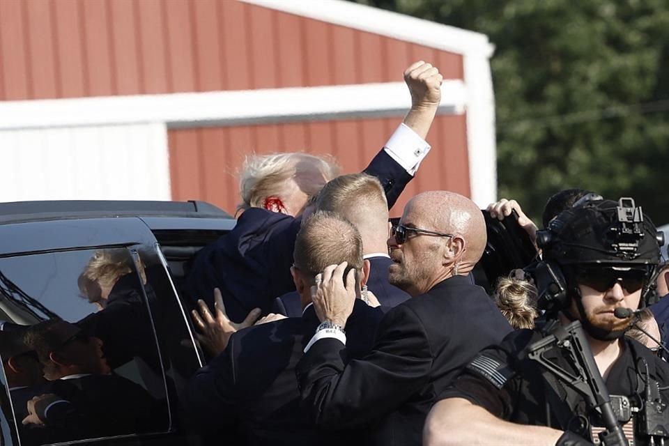 El ex Presidente Donald Trump es subido a su auto tras un ataque en un mitin en Pensilvania.