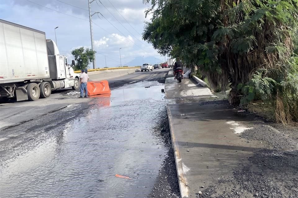 En ese tramo, los automóviles y tráileres circulan sobre la corriente de agua sucia, salpicando a quienes por ahí caminan.