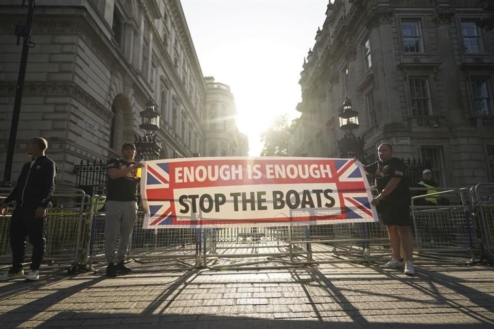 Manifestantes sostienen un cartel que dice 'Suficiente, detengan los botes' en Londres.