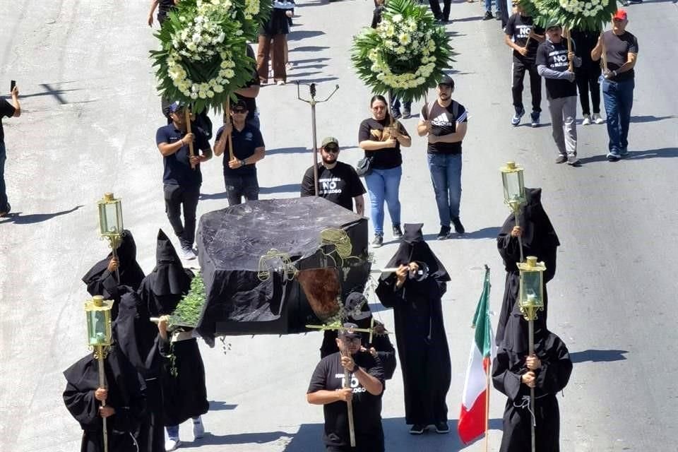 La marcha incluyó un cortejo fúnebre con personas vestidas de negro y rostro cubierto que cargaban el féretro de la justicia.