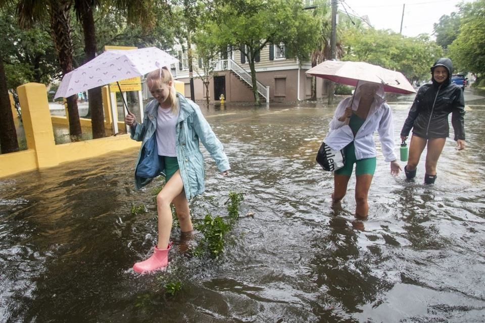 Personas se abren paso a través de las calles inundadas en Charleston el 6 de agosto del 2024.