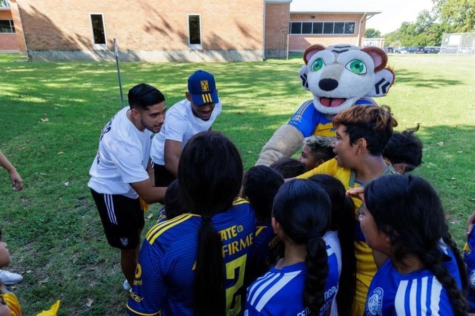 Los jugadores Jesús Garza (izq.) y Joaquim Pereira conviven con niñas y niños en Austin, Texas.