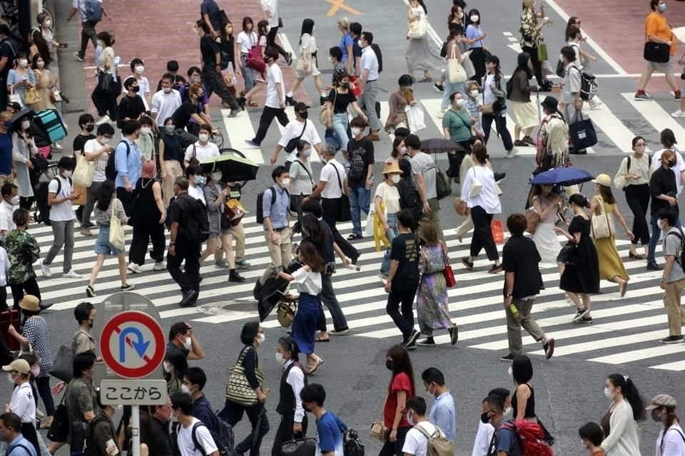 Personas con cubrebocas caminan por las calles de Tokio.