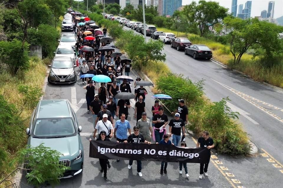 Los trabajadores portan una manta con la consigna 'Ignorarnos no es diálogo', rumbo a otra sede del Poder Judicial.