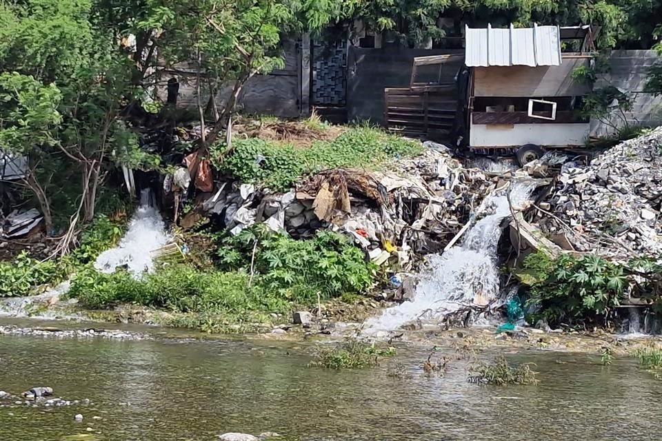 Tres caídas de agua se forman en una orilla del Río Santa Catarina, en medio de un tiradero de basura y escombro.