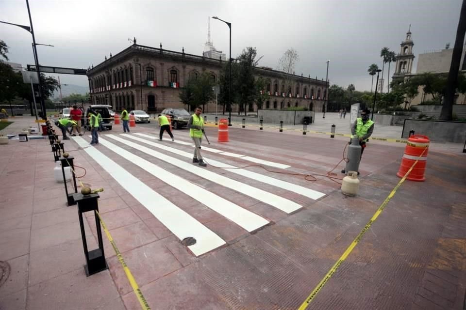 Trabajadores pintan rayas de paso peatonal y cierran el carril derecho de Zuazua, a la altura del Palacio de Gobierno, en el Centro.