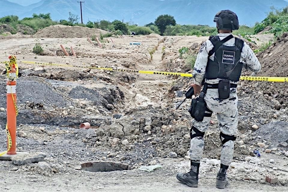 Un policía custodia la zona donde ayer fueron baleados seis hombres, de los cuales sólo uno sobrevivió, en Juárez.