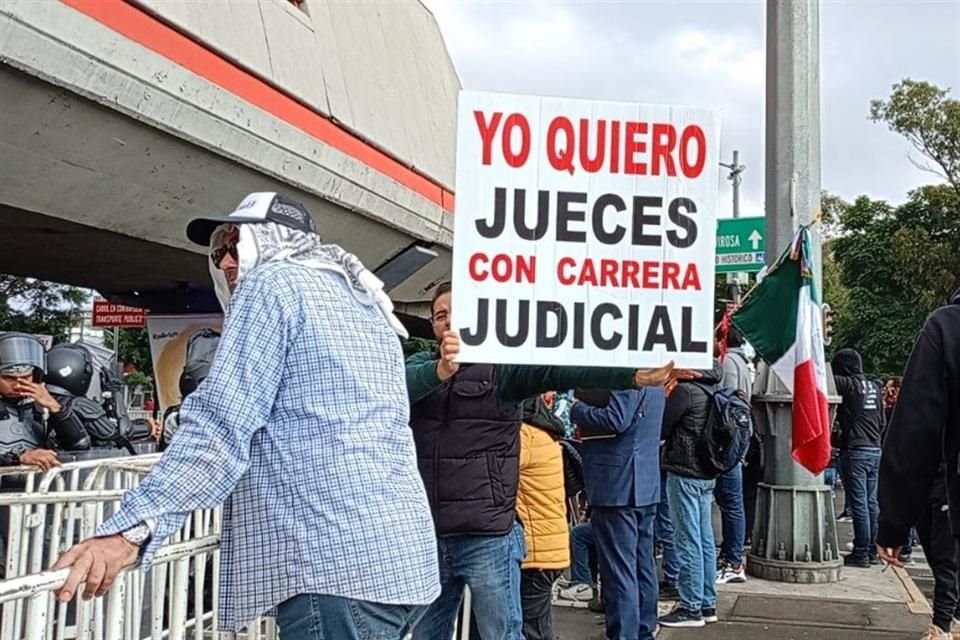 Un trabajador muestra una cartulina en defensa de la carrera judicial.