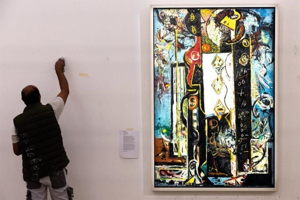 Personal del museo daba este lunes los últimos toques al montaje de la exposición de Pollock en París; a su lado el cuadro 'Masculino y femenino'.