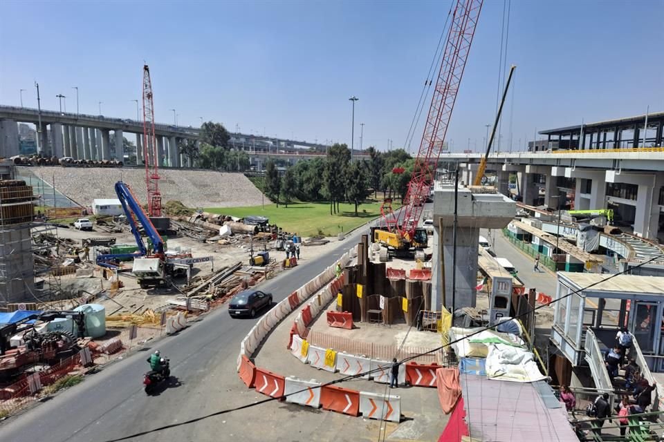 Las personas tienen que pasar por un pasillo hecho por trabajadores en las obras. 