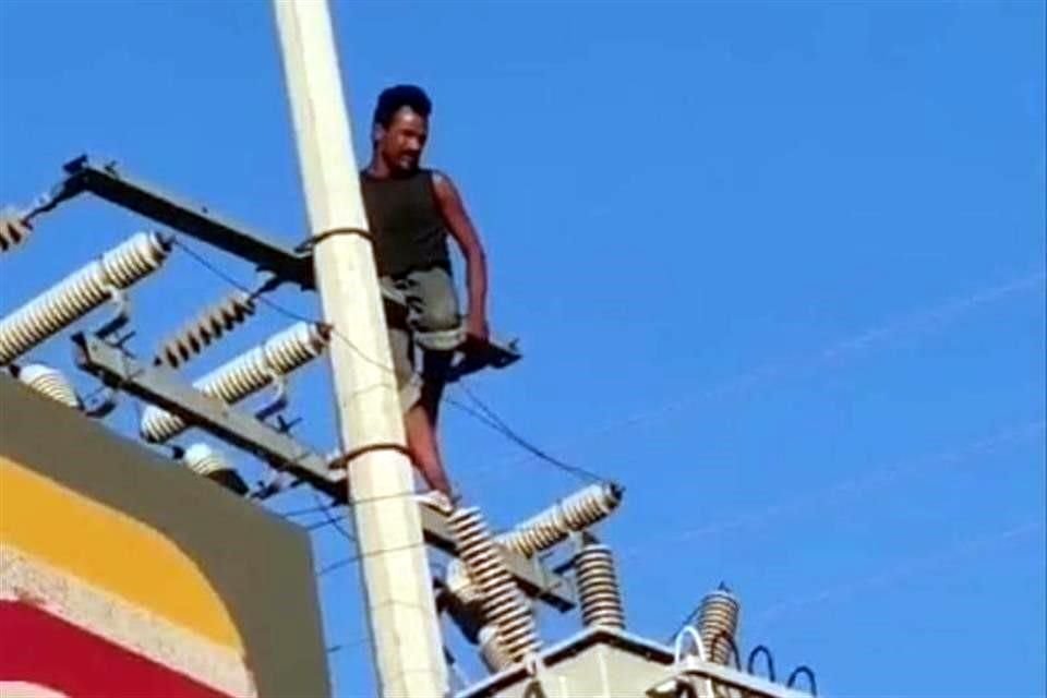 Después de unos minutos de estar suspendido en los cables, el hombre bajó y fue detenido por la Policía Municipal por alterar el orden.