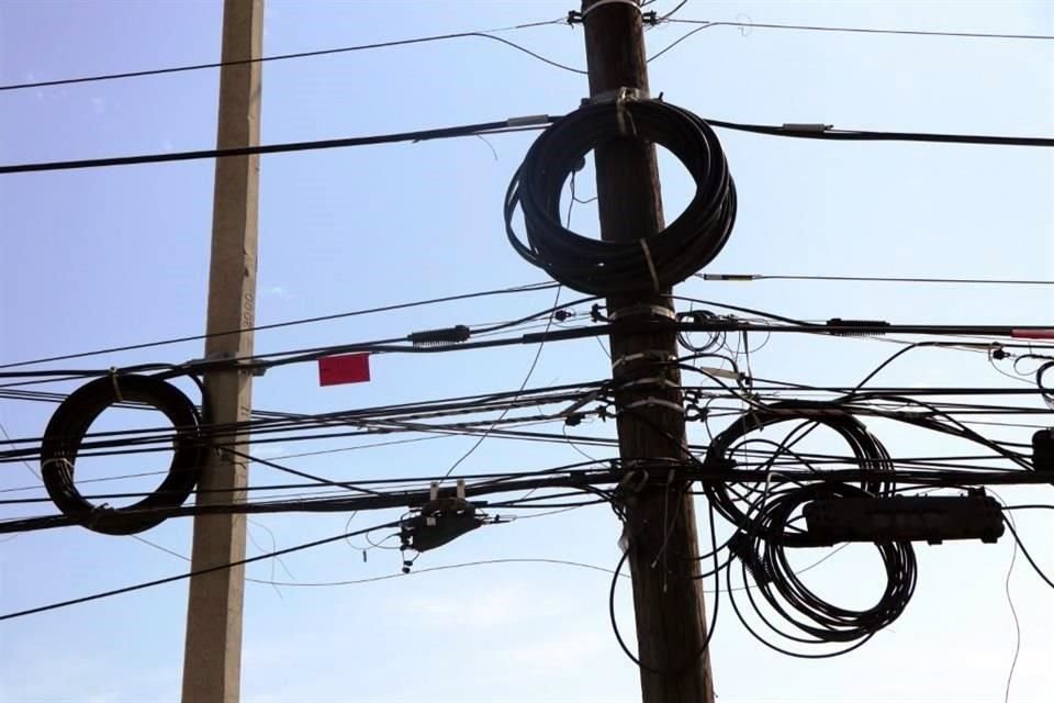 Compañías dejan rollos de cable colgados en los postes de la Ciudad.