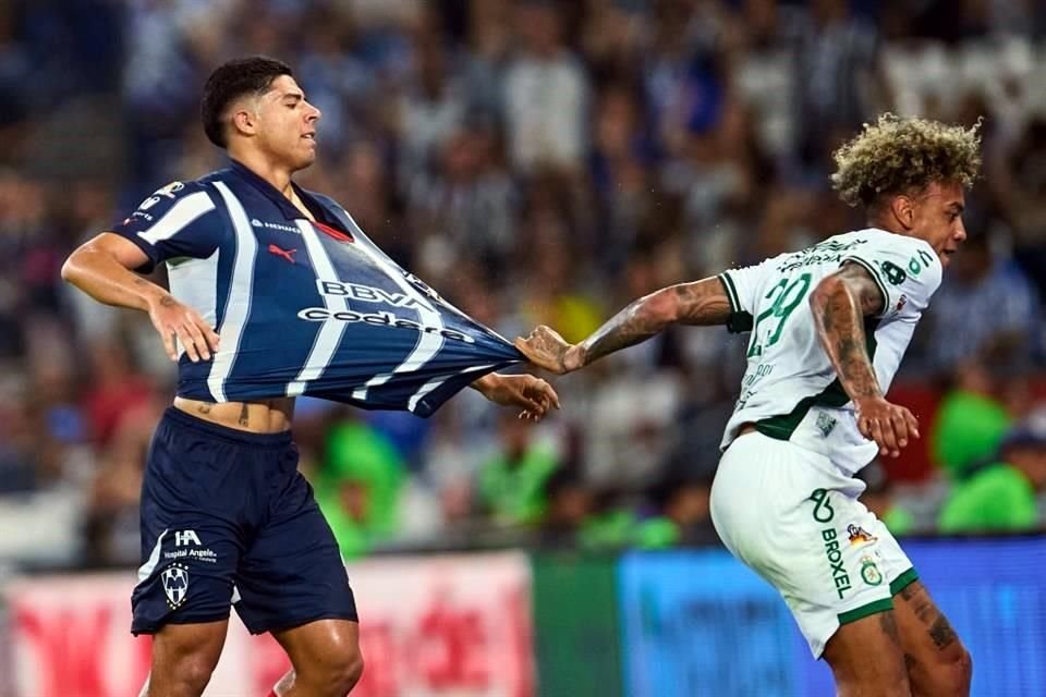 Victor Guzman (izquierda) es sujetado de la camiseta por Jhonder Cadiz, del León.