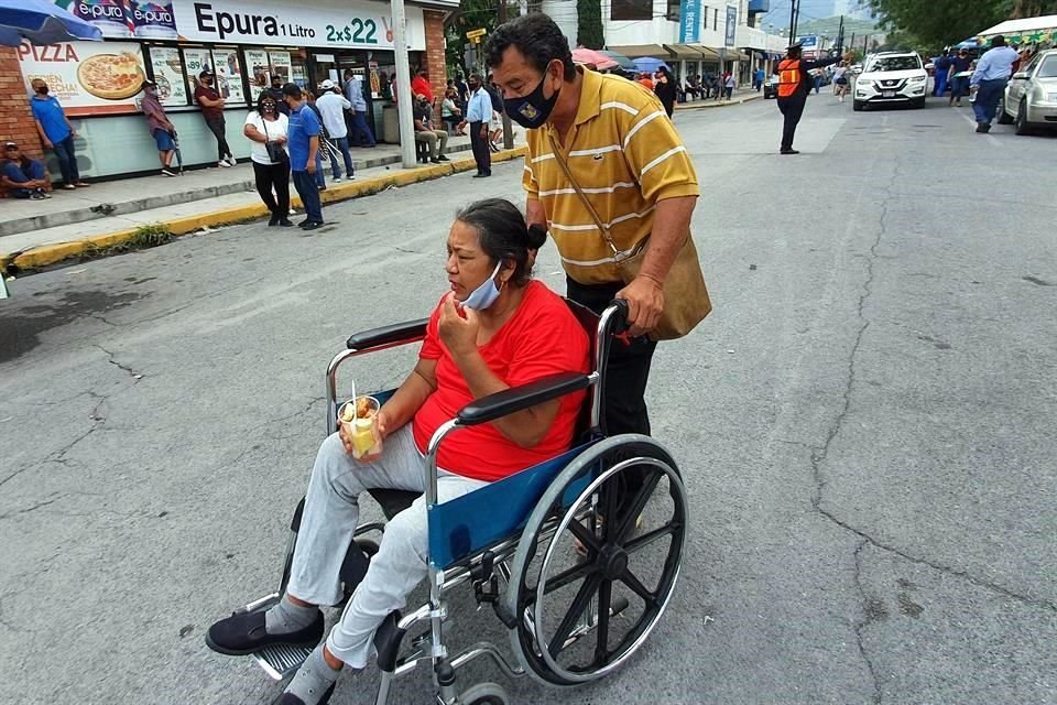 Regino Méndez, de 56 años, ayuda a su esposa Rosa González, de 58 años, quien usa silla de ruedas tras sufrir una embolia que le paralizó una parte del cuerpo.