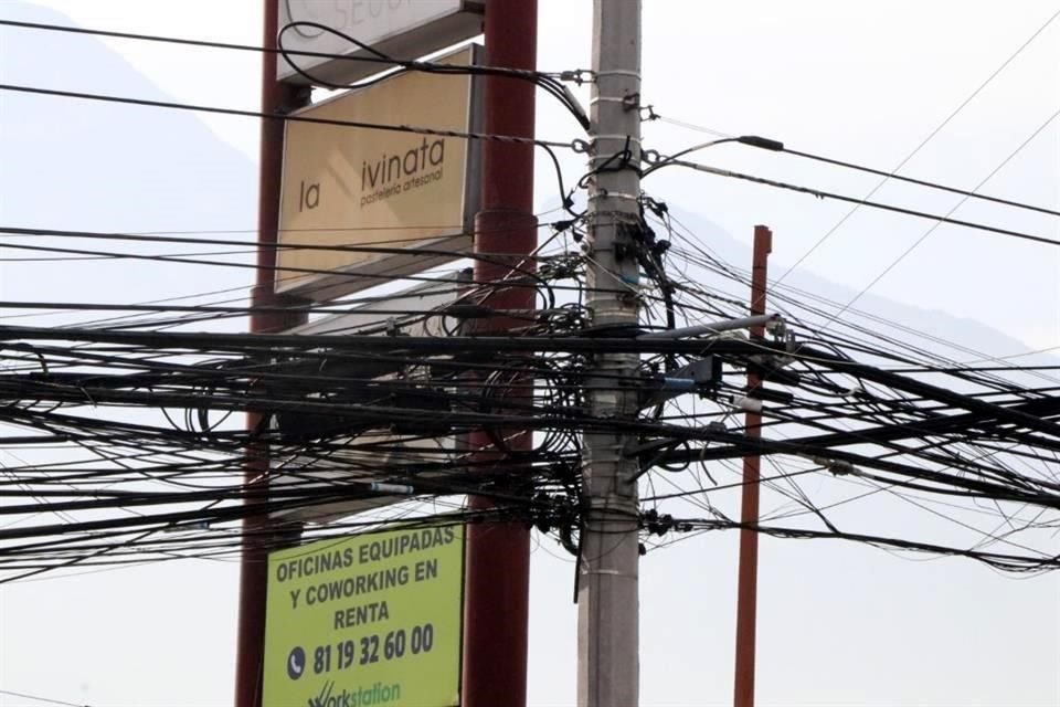 Telarañas de cables suman años sin ser removidas, en Vasconcelos y Paseo de los Conquistadores, en San Pedro. 