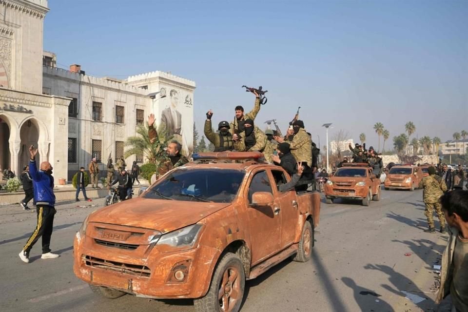 Combatientes sirios antigubernamentales celebran luego de capturar la ciudad de Hama.