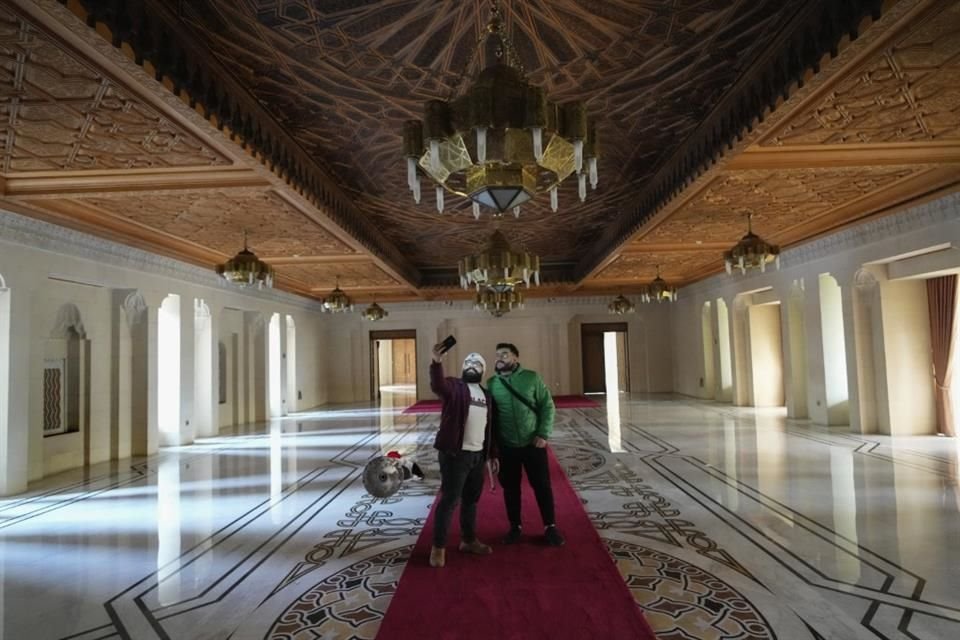 Dos hombres se toman una selfie en los pasillos del palacio presidencial de Assad en Damasco.