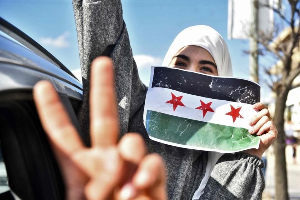 Los sirios celebran la toma de la capital, Damasco, por parte de los combatientes rebeldes sirios, en la ciudad de Bar Elias, en el centro del Líbano, en el valle de Bekaa.