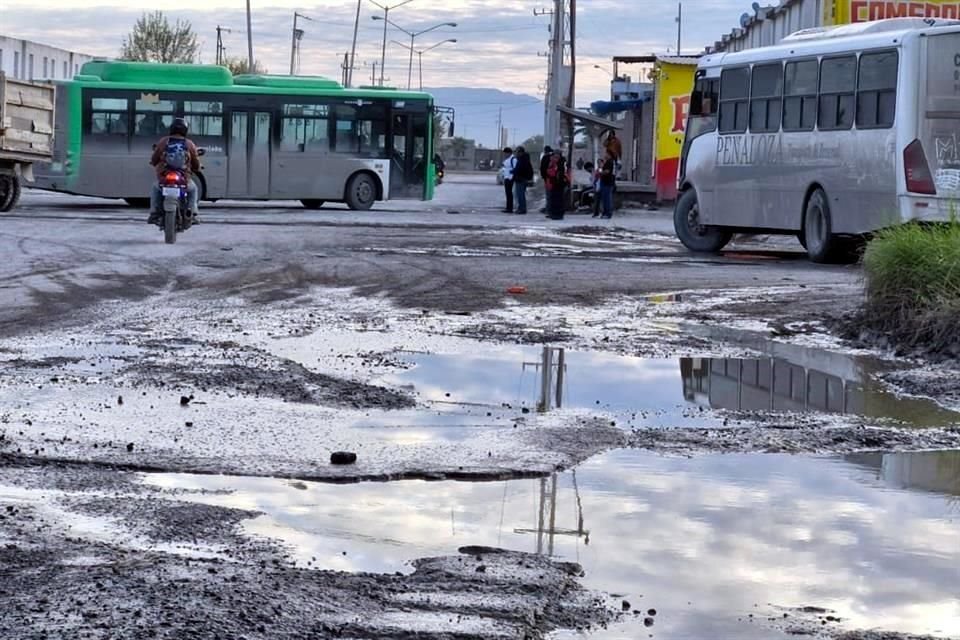  Los vecinos tienen que caminar entre los charcos y baches para cruzar las calles. 