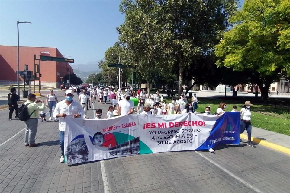 En compañía de sus hijos, decenas de papás del movimiento '¡Abre Mi Escuela!' caminaron con mantas y pancartas por las calles Zuazua y Matamoros.