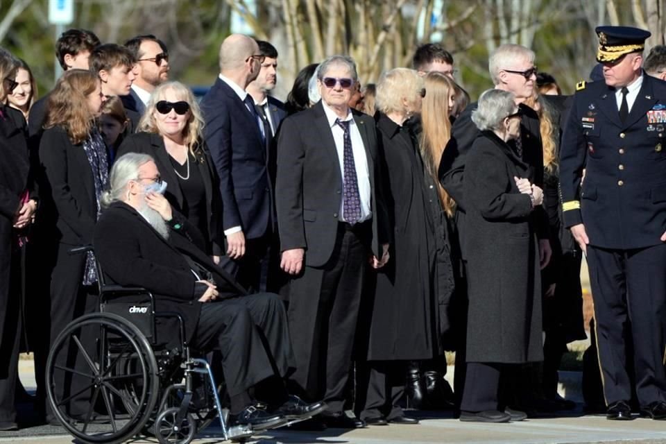 Miembros de la familia Carter esperan antes de que el ataúd cubierto con la bandera del ex presidente estadounidense Jimmy Carter salga del Centro Médico Phoebe Sumter en Americus, Georgia.