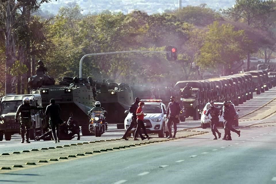 Entre humo rojo lanzado por opositores, soldados detuvieron a algunos manifestantes que bloqueaban en paso del convoy.