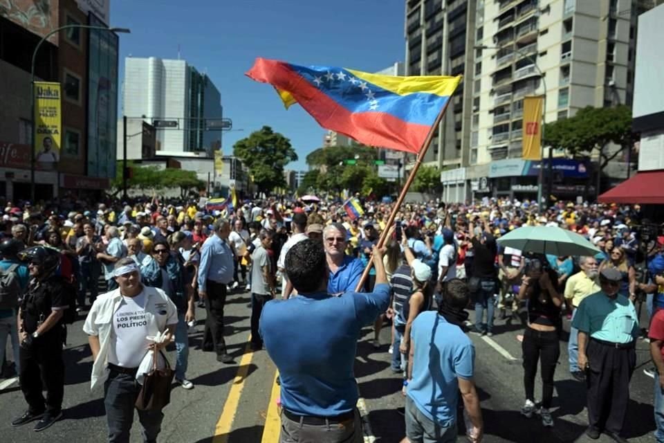 Un manifestante ondea una bandera venezolana durante una protesta convocada por la oposición en vísperas de la investidura presidencial en Caracas.