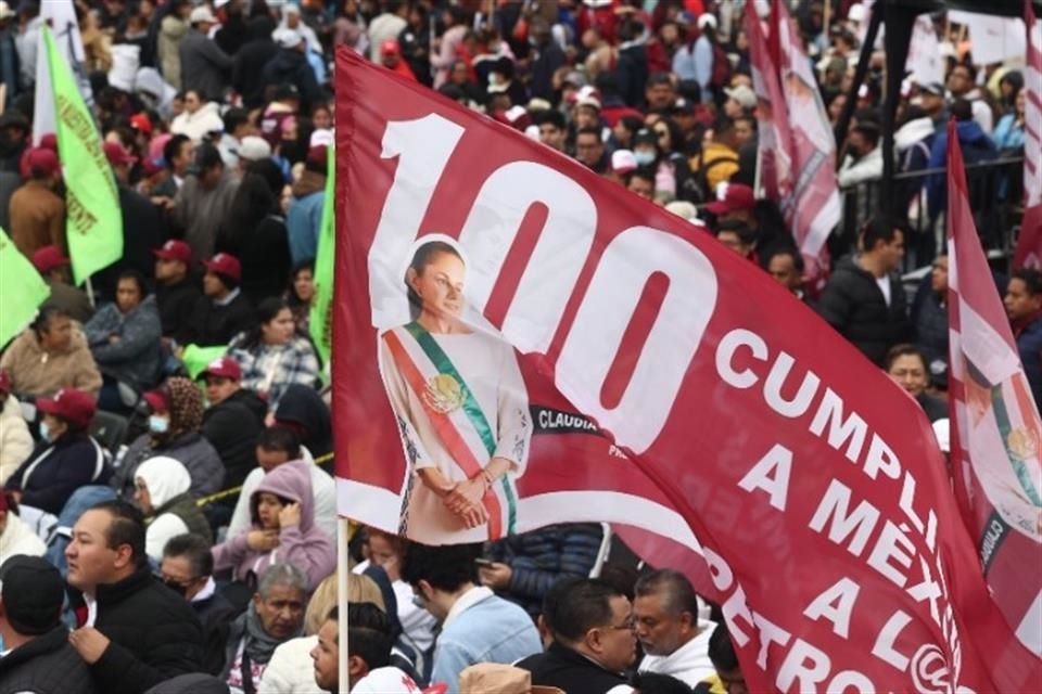 Una bandera con la figura de Claudia Sheinbaum y el número 100 ondea entre los simpatizantes en el Zócalo capitalino.