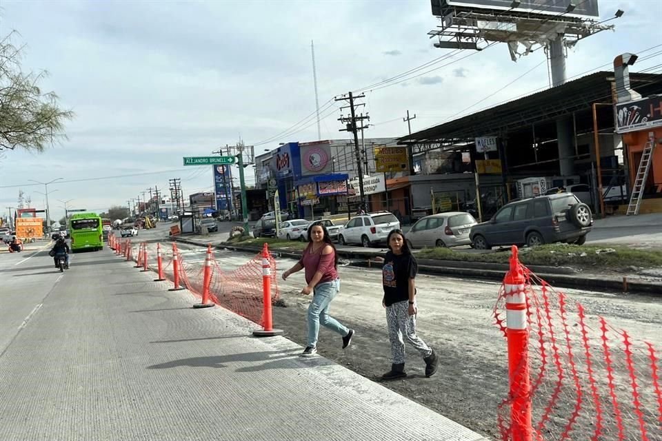 Para cruzar la Avenida Eloy Cavazos, los peatones tienen que rodear las obras o brincar la malla naranja que impide el paso.