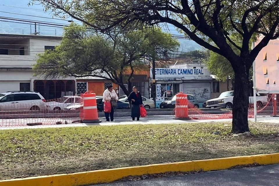 Para cruzar la Avenida Eloy Cavazos, los peatones tienen que rodear las obras o brincar la malla naranja que impide el paso.