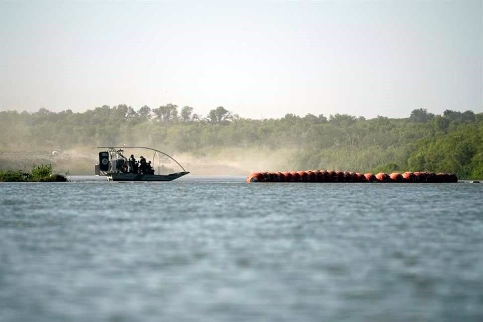 Un bote de la Patrulla fronteriza pasa al lado de las boyas colocadas en el Río Bravo, en la frontera con Texas.