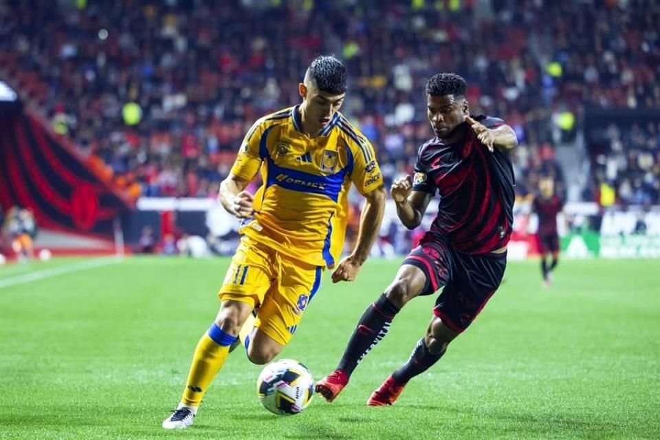 Juan Brunetta (izq.), de Tigres, conduce el balón ante la marca de Raúl Zúñiga, de Xolos, en el último duelo ante estos equipos.