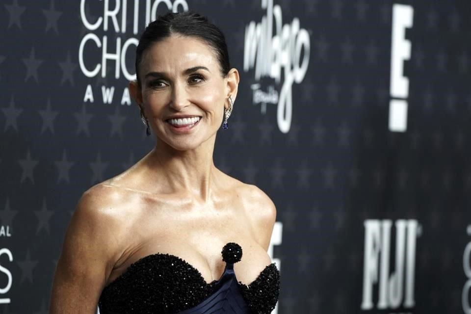 Demi Moore posó antes las cámaras en la alfombra, con un ajustado vestido negro.